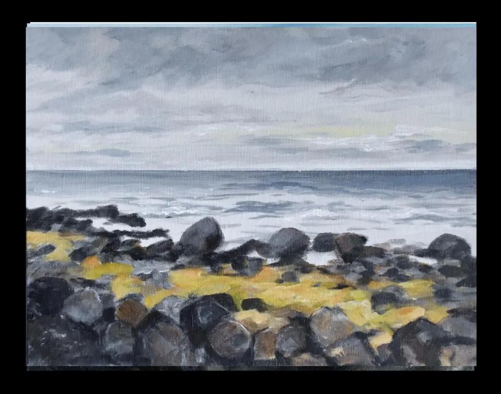 Steiner med gress imellom og havet utenfor