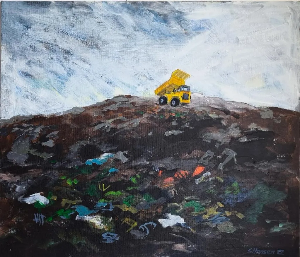 en gul lastebil på toppen av en søppelfylling