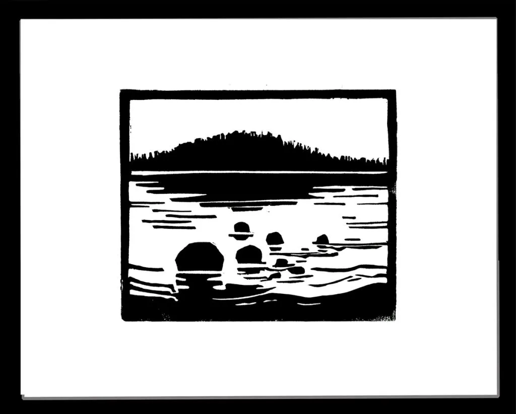 en stille kveld ved sjøen med noen steiner i forgrunnen