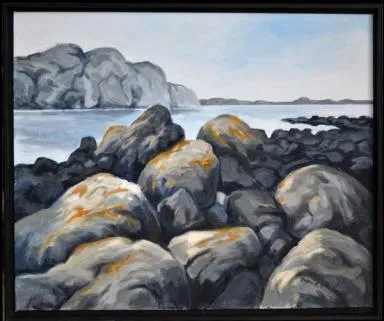 Store steiner ligger ved vannkanten og landskap i bakgrunnen